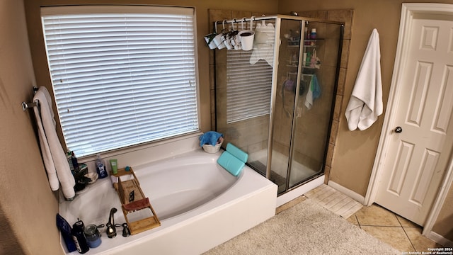 bathroom with plus walk in shower, a wealth of natural light, and tile patterned flooring