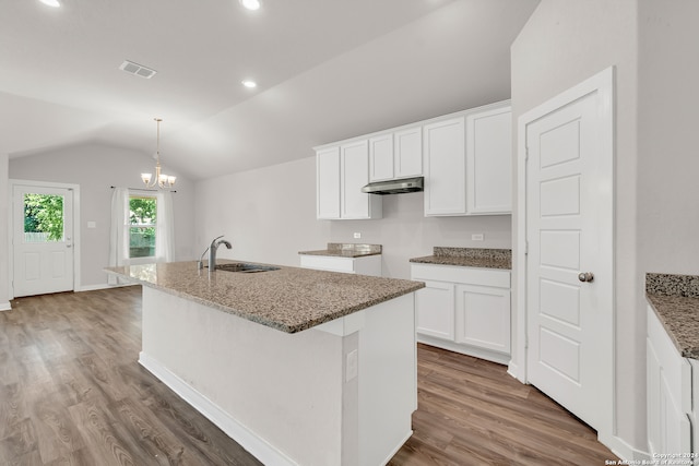 kitchen featuring sink, vaulted ceiling, white cabinets, dark wood-type flooring, and a kitchen island with sink