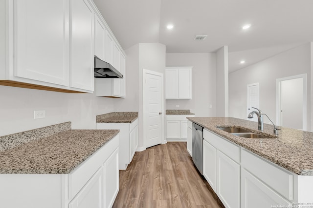 kitchen with a kitchen island with sink, sink, white cabinets, light stone counters, and light hardwood / wood-style floors