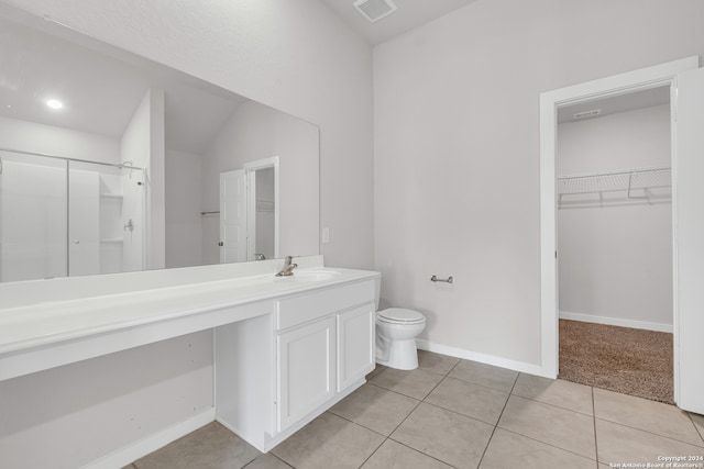 bathroom with walk in shower, vaulted ceiling, toilet, vanity, and tile patterned floors