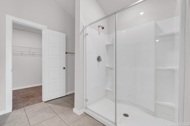 bathroom with lofted ceiling, tile patterned flooring, and an enclosed shower