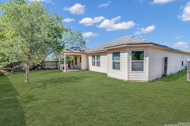 back of property with a patio and a lawn