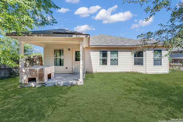 back of house with a yard and a patio