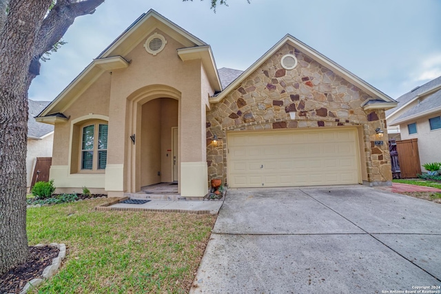 3718 Willow Walk, San Antonio, TX 78259 - view of front of house featuring stone siding, concrete driveway, stucco siding, a garage, and a front yard