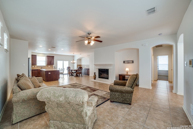 living room featuring ceiling fan, light tile patterned floors, and plenty of natural light