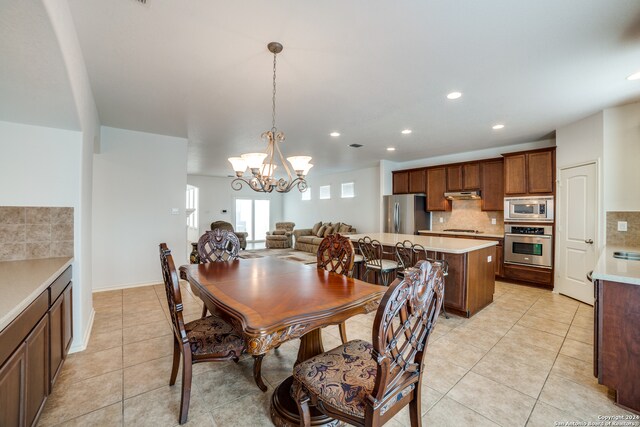 dining room featuring light tile patterned flooring and an inviting chandelier