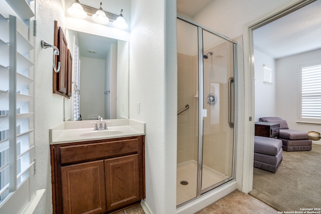 bathroom featuring vanity and a shower with shower door