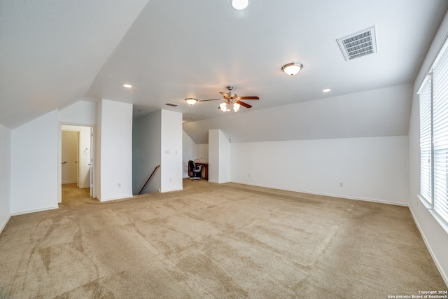 additional living space featuring ceiling fan, light colored carpet, and vaulted ceiling