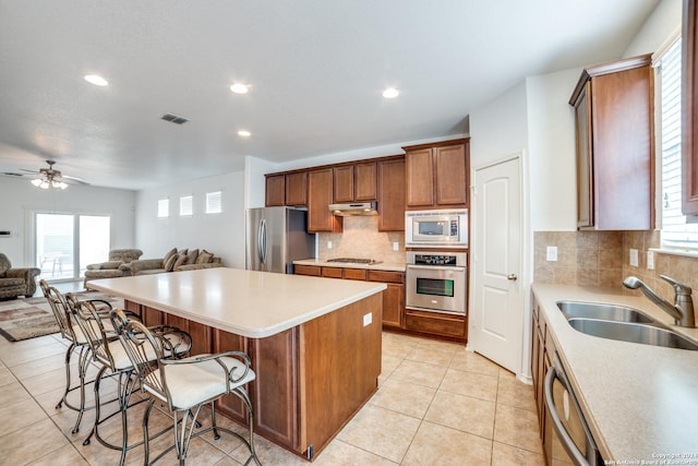 3718 Willow Walk, San Antonio, TX 78259 - kitchen with stainless steel appliances, a sink, open floor plan, a center island, and a kitchen bar