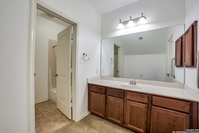 bathroom featuring  shower combination, vanity, and tile patterned flooring