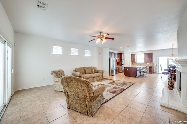 living room with ceiling fan, light tile patterned flooring, and a wealth of natural light