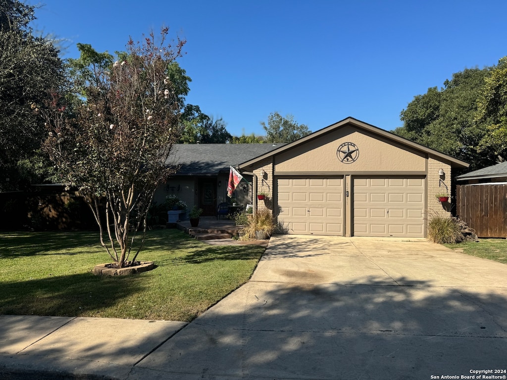 ranch-style home with a front lawn and a garage