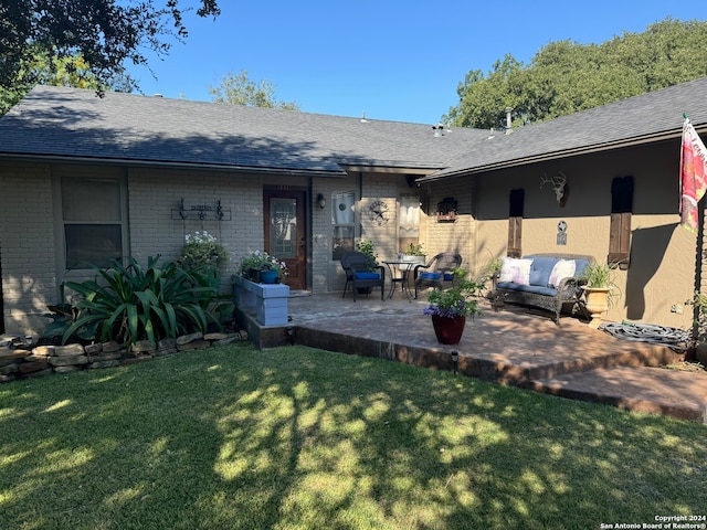 back of property with a yard and a patio