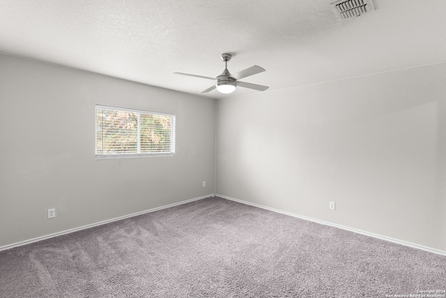 carpeted spare room with a textured ceiling and ceiling fan