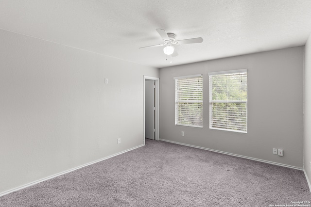 unfurnished room with a textured ceiling, carpet, and ceiling fan