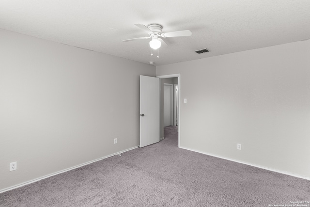 carpeted spare room with a textured ceiling and ceiling fan