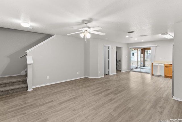 unfurnished living room featuring a textured ceiling, light wood-type flooring, and ceiling fan