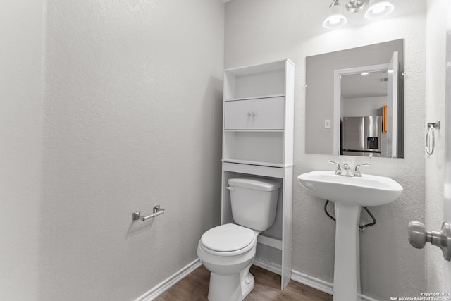 bathroom featuring toilet and wood-type flooring