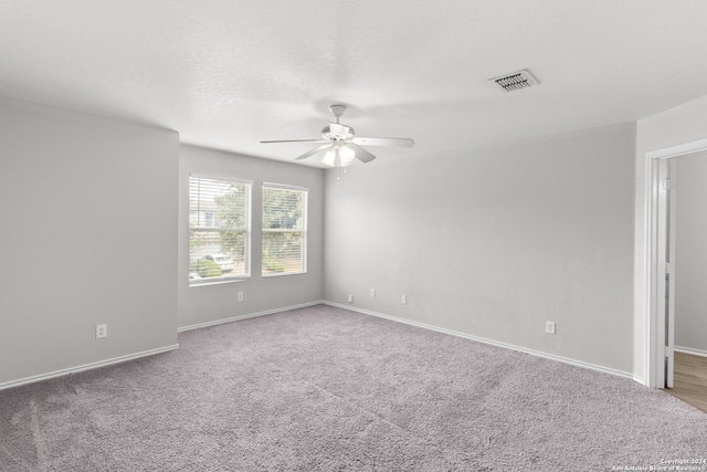 carpeted spare room with ceiling fan