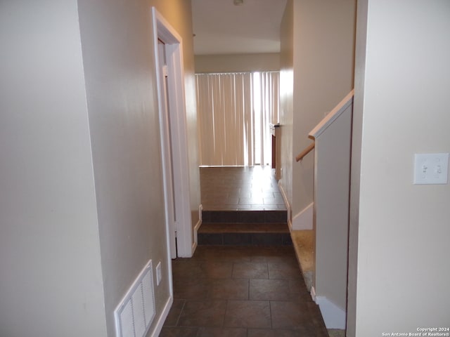 hallway featuring dark tile patterned flooring