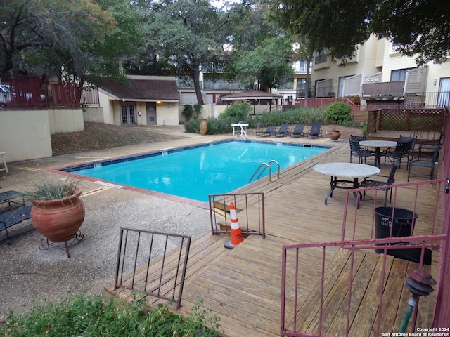 view of swimming pool featuring a deck and a patio area