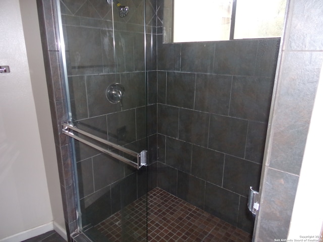 bathroom with a shower with door