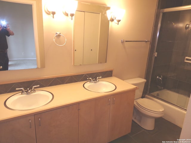 full bathroom featuring backsplash, shower / bath combination with glass door, toilet, vanity, and tile patterned floors