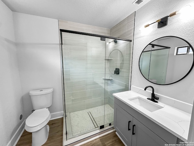 bathroom featuring vanity, wood-type flooring, toilet, and an enclosed shower