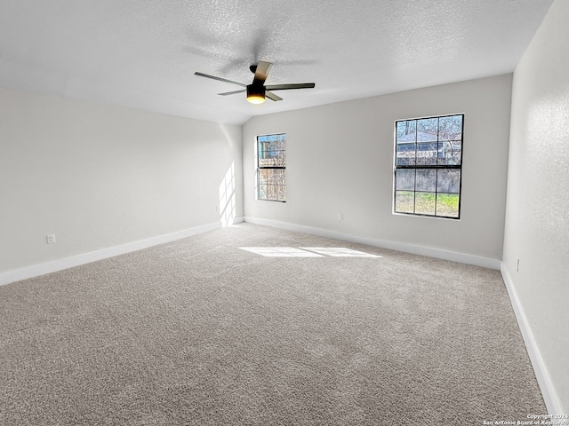 carpeted empty room featuring ceiling fan and a textured ceiling