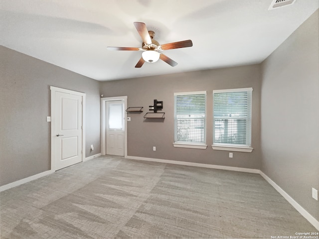 carpeted spare room featuring ceiling fan