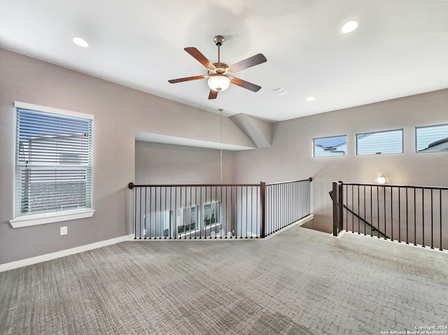 carpeted spare room featuring ceiling fan