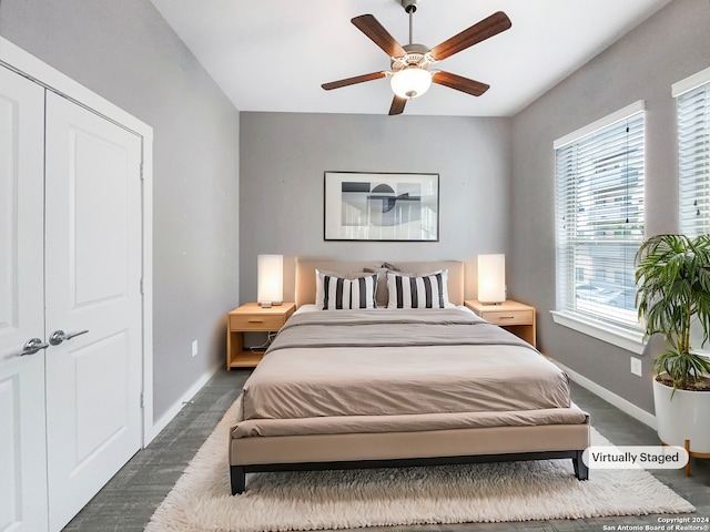 bedroom featuring dark colored carpet, a closet, and ceiling fan