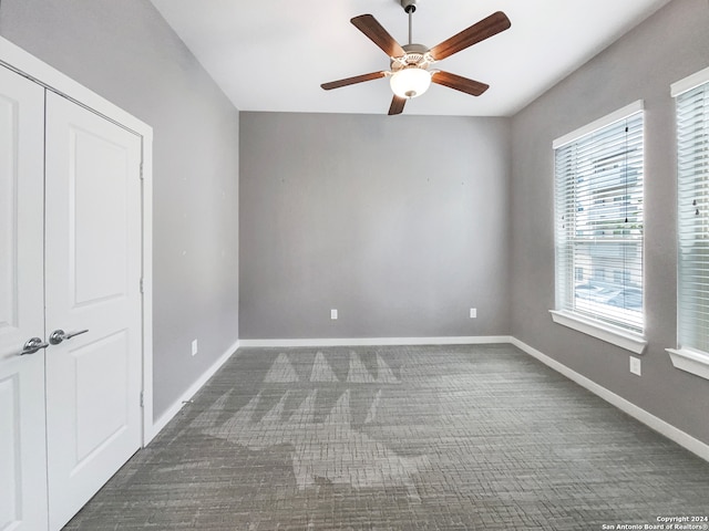 unfurnished bedroom featuring a closet, ceiling fan, and dark colored carpet