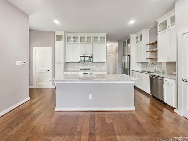 kitchen featuring a center island, white cabinetry, dark wood-type flooring, and stainless steel appliances