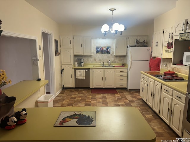 kitchen featuring tasteful backsplash, appliances with stainless steel finishes, hanging light fixtures, white cabinets, and a notable chandelier