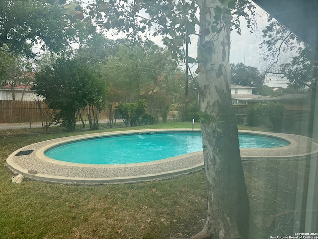 view of swimming pool with a lawn