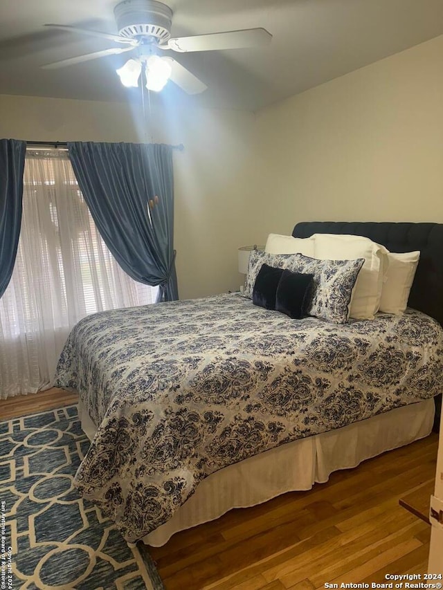 bedroom with ceiling fan and hardwood / wood-style flooring