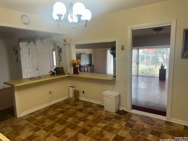 kitchen with an inviting chandelier, kitchen peninsula, and pendant lighting