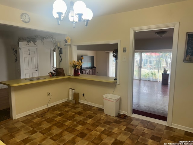 kitchen with kitchen peninsula, a notable chandelier, and pendant lighting