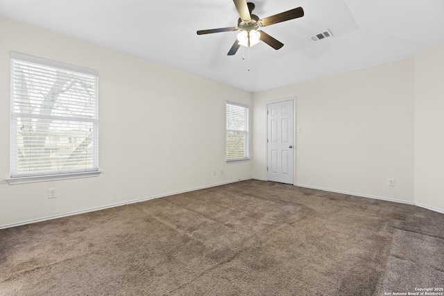 empty room with vaulted ceiling, ceiling fan, and carpet floors