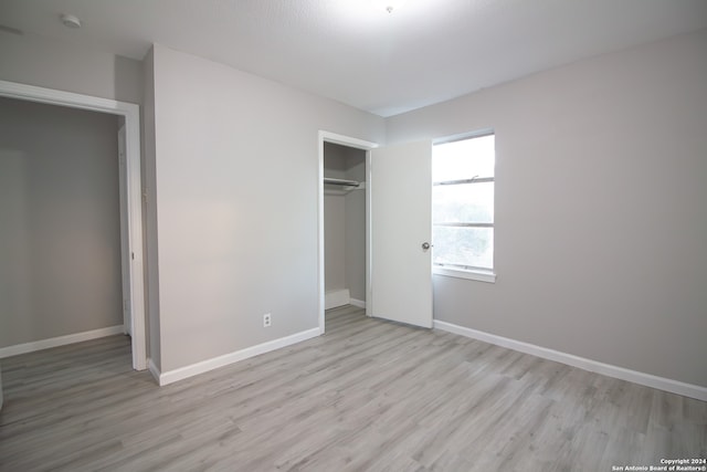 unfurnished bedroom with a closet and light hardwood / wood-style flooring