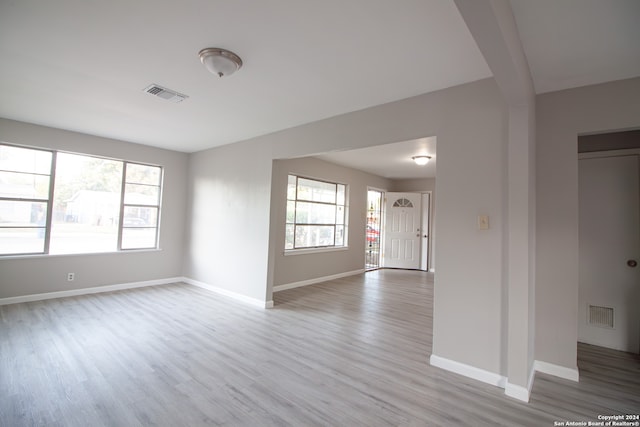 spare room with a healthy amount of sunlight and light hardwood / wood-style flooring