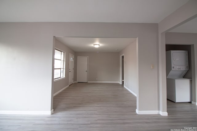 corridor featuring light hardwood / wood-style floors and stacked washer and clothes dryer