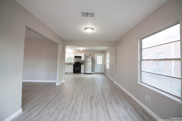 unfurnished living room with light hardwood / wood-style flooring and sink