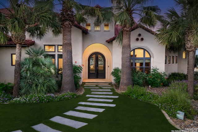 view of front of house with french doors and a front lawn