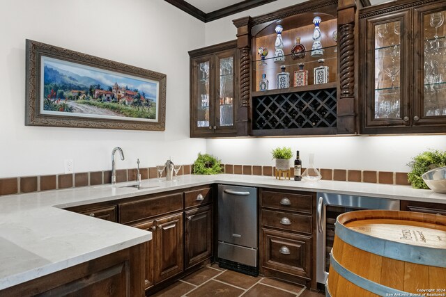 bar featuring dark tile patterned flooring, sink, wine cooler, dark brown cabinetry, and crown molding