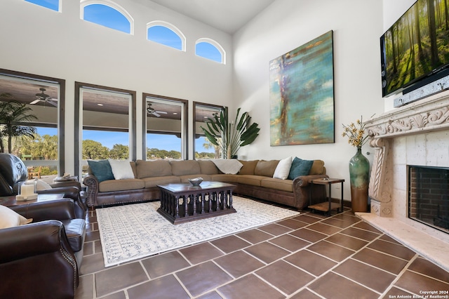 living room with dark tile patterned flooring, a high ceiling, and a fireplace