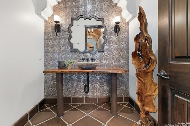 bathroom featuring decorative backsplash, sink, and tile patterned flooring