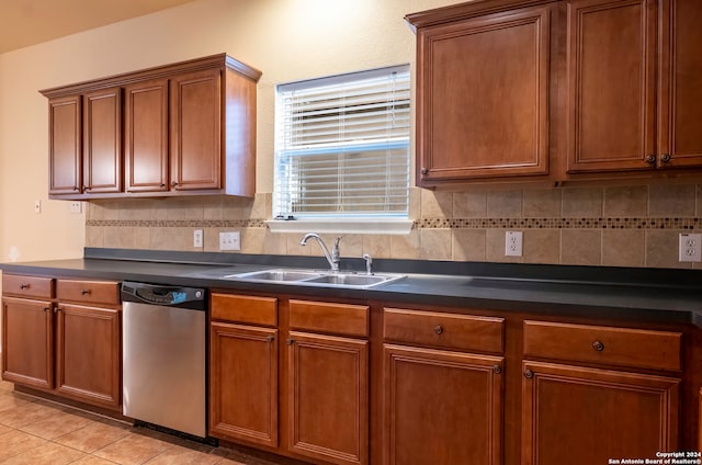 kitchen featuring decorative backsplash, stainless steel dishwasher, sink, and light tile patterned floors