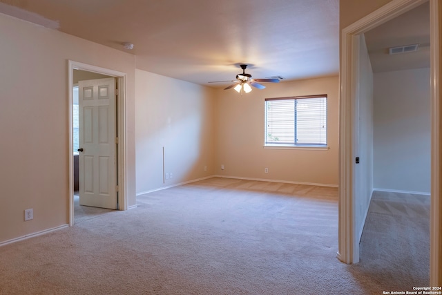 carpeted spare room with ceiling fan